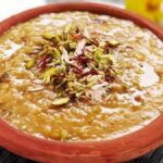 छठ खरना 2025 पर गुड़ की खीर बनाते हुए महिला, मिट्टी के चूल्हे पर प्रसाद तैयार करते हुए दृश्य