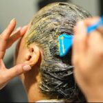 किचन की चीजों से बनी नेचुरल हेयर डाई लगाती हुई महिला, बालों में ऑलिव ऑयल और कॉफी मिश्रण लगाते हुए