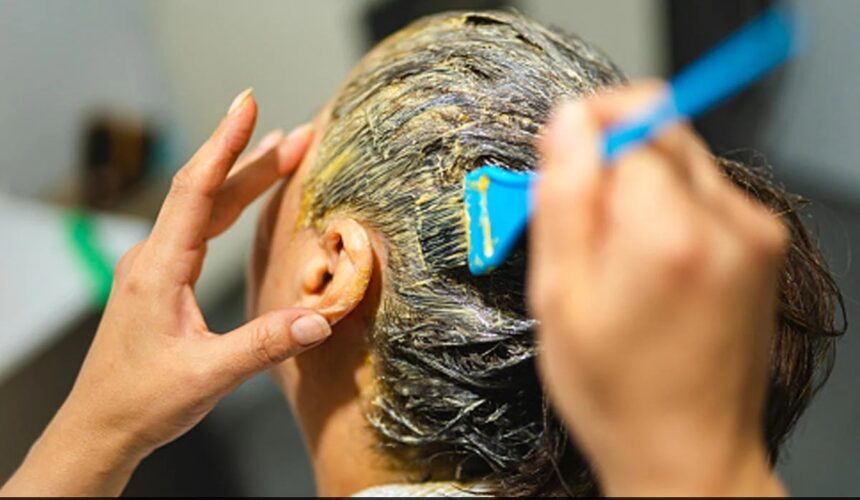 किचन की चीजों से बनी नेचुरल हेयर डाई लगाती हुई महिला, बालों में ऑलिव ऑयल और कॉफी मिश्रण लगाते हुए