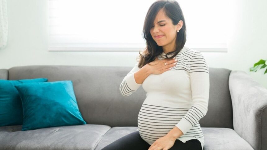 प्रेग्नेंसी में उल्टी और मतली से परेशान महिला, डॉक्टर के टिप्स अपनाती हुई