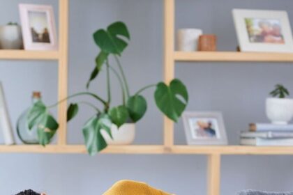 महिला पेट पर हाथ रखकर पीरियड क्रैम्प्स से राहत पाने के लिए योग और गर्म पानी का उपयोग करती हुई।