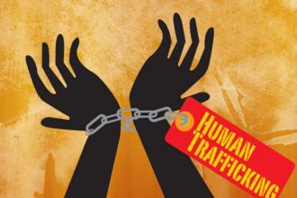 एक प्रतीकात्मक दृश्य जिसमें एक महिला अंधेरे में खड़ी दिखाई दे रही है, जो मानव तस्करी के कारण महिलाओं की छीनी गई आज़ादी और असुरक्षा को दर्शाता है।