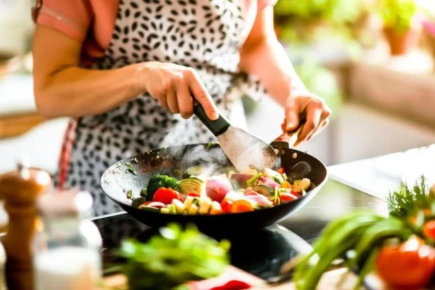 महिला रसोई में स्मार्ट प्लानिंग के साथ रोज़ का खाना बनाते हुए