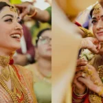 पारंपरिक भारतीय दुल्हन लाल और सुनहरे लहंगे में, भारी गोल्ड ज्वेलरी पहने हुए, शादी की रस्म के दौरान मुस्कुराती हुई