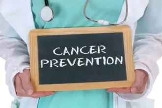 Doctor holding a board with Cancer Prevention message, highlighting the importance of healthy lifestyle choices and early prevention strategies.