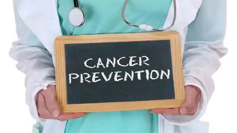 Doctor holding a board with Cancer Prevention message, highlighting the importance of healthy lifestyle choices and early prevention strategies.