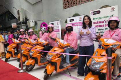 Women riders with orange EV scooters during the launch of Lucknow Metro's MyDidi Women-Only EV Bike Shuttle Service, promoting safe last-mile connectivity and women empowerment in Lucknow.
