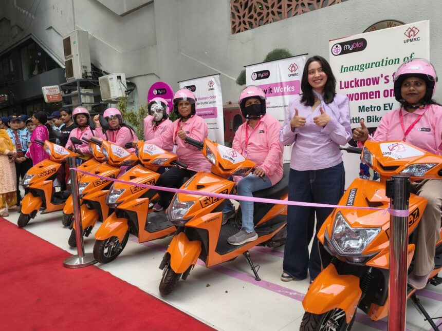 Women riders with orange EV scooters during the launch of Lucknow Metro's MyDidi Women-Only EV Bike Shuttle Service, promoting safe last-mile connectivity and women empowerment in Lucknow.
