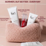 Hart skincare summer essentials kit featuring Cleansing Milk Cream, Apple Jelly Lip Drip, and Dewy Brightening Cream displayed in a soft pink textured pouch against a pastel pink tiled background.