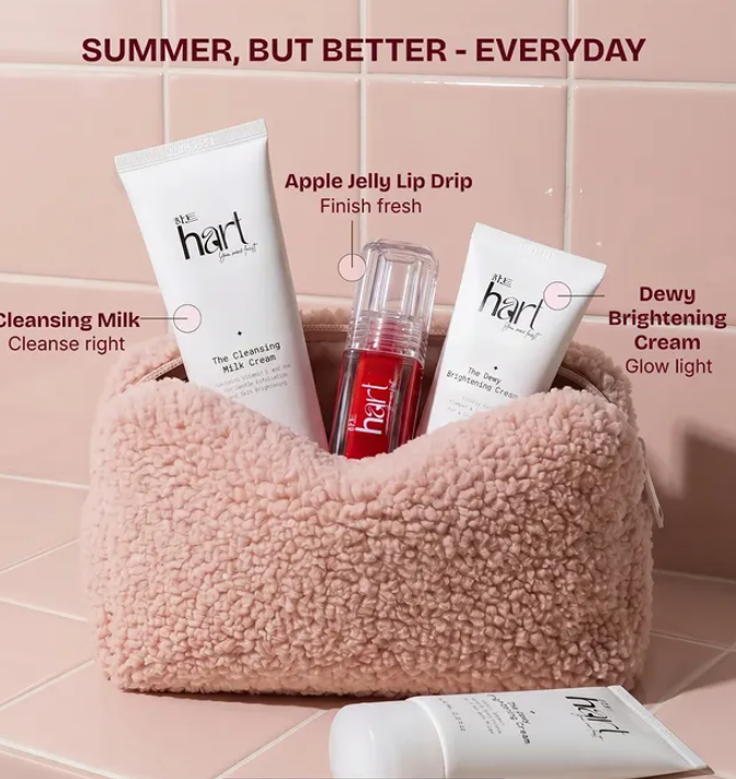 Hart skincare summer essentials kit featuring Cleansing Milk Cream, Apple Jelly Lip Drip, and Dewy Brightening Cream displayed in a soft pink textured pouch against a pastel pink tiled background.