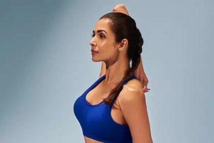 Malaika Arora performing a yoga stretch in a royal blue workout outfit, showcasing flexibility, fitness, and a healthy lifestyle.