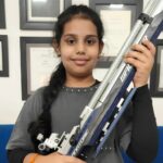 Naira Sharma holding an air rifle after qualifying for the national shooting competition