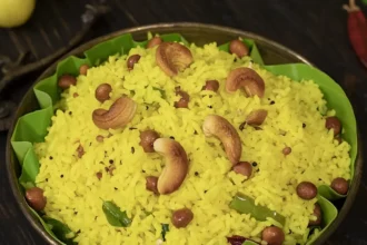 Traditional Indian lemon rice garnished with cashews, peanuts and curry leaves