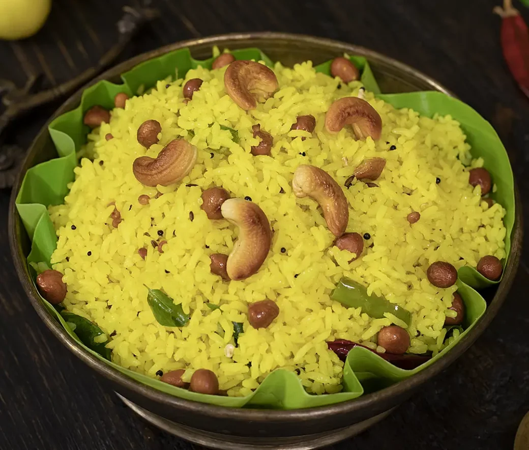 Traditional Indian lemon rice garnished with cashews, peanuts and curry leaves