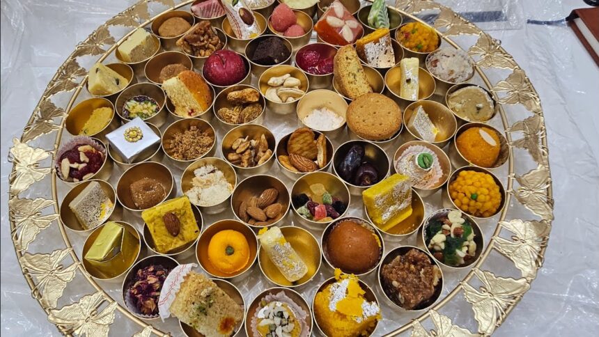 A beautifully arranged traditional Indian sweet platter featuring assorted mithai, dry fruits, and festive delicacies in small golden bowls.
