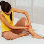 Woman experiencing a painful leg cramp at night